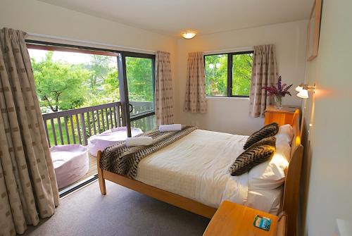 a bedroom with a bed and a balcony at Crescent House in Wanaka