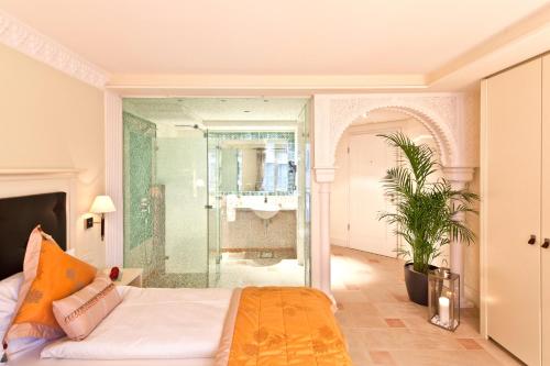 sypialnia z łóżkiem i przeszklonym prysznicem w obiekcie Boutiquehotel La Casa w Tybindze