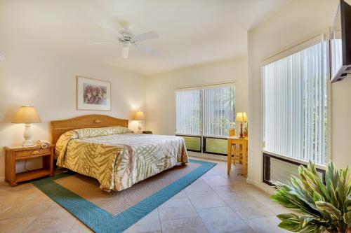 a bedroom with a bed and two windows at Castle Kanaloa at Kona in Kailua-Kona