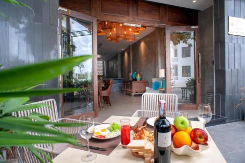 uma mesa com uma taça de fruta e uma garrafa de vinho em Sen Boutique Villa Apartment em Da Nang