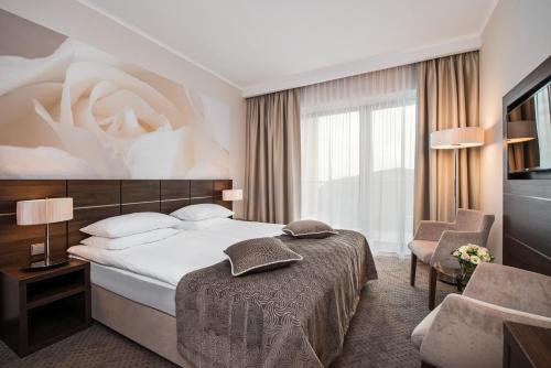Pokój hotelowy z łóżkiem i krzesłem w obiekcie Hotel Różany Gaj w mieście Gdynia