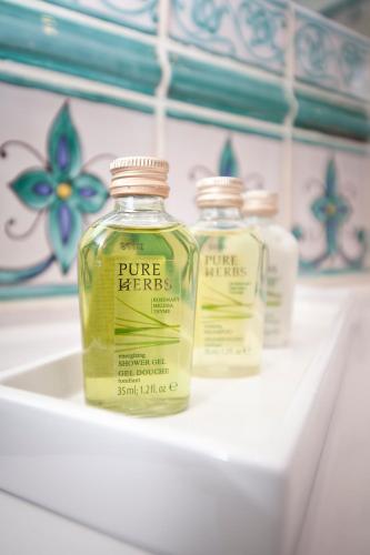 three bottles of pure herbs sitting on a shelf at Boutiquehotel La Casa in Tübingen