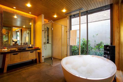 a large bathroom with a tub and a shower at Baba Beach Club Natai Luxury Pool Villa Hotel by Sri panwa - SHA Plus in Natai Beach