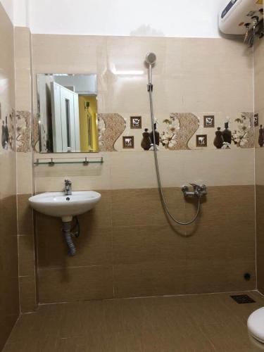 a bathroom with a sink and a shower with a mirror at Thu Linh Homestay in Da Lat