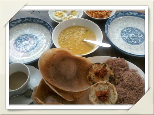 a table with plates of food and a bowl of soup at Secret Palace Guest house in Galle