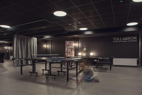a person sitting on the floor next to a ping pong table at Best Western Plus Hus 57 in Ängelholm