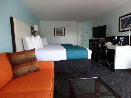 a hotel room with a bed and a couch at Best Western Plus Orlando Lake Buena Vista South Inn & Suites in Kissimmee