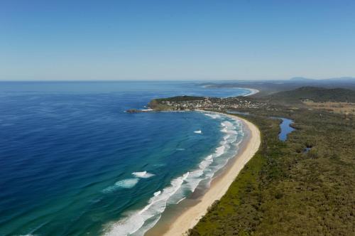 an aerial view of a beach and the ocean at Crescent Head Holiday Park in Crescent Head