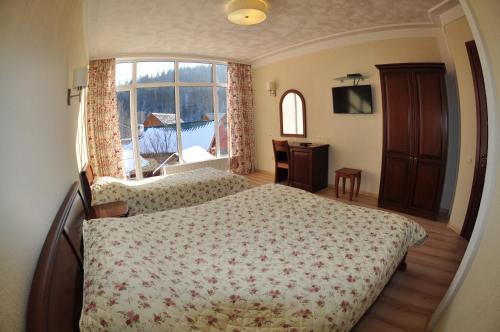 1 dormitorio con cama y ventana grande en Villa Provans, en Tatariv