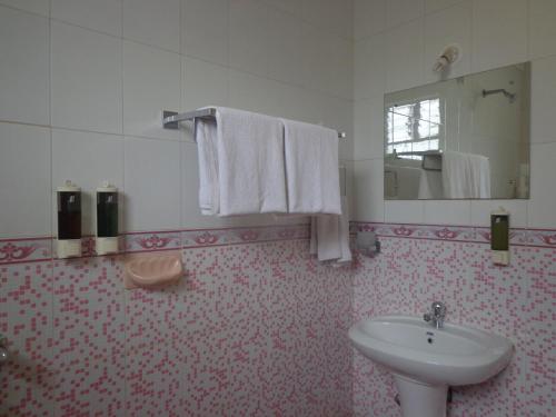 bagno con lavandino e specchio di The Tubki Resort a Palolem