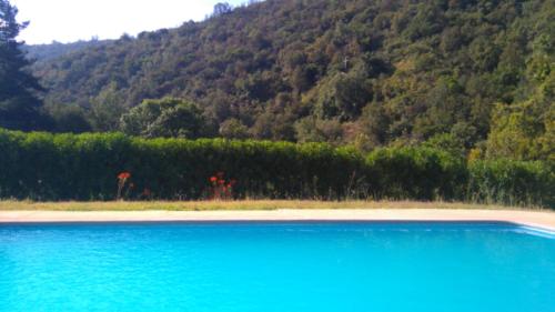 a large pool of blue water in front of a mountain at Refugios Olmue Santa Teresa in El Maqui