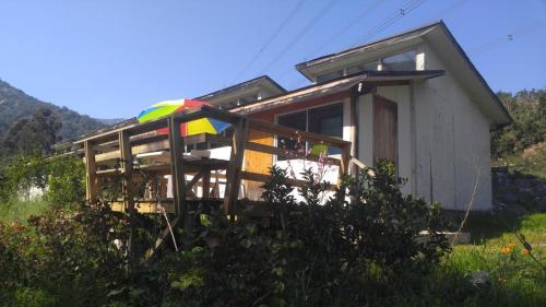 a house with a colorful umbrella in front of it at Refugios Olmue Santa Teresa in El Maqui