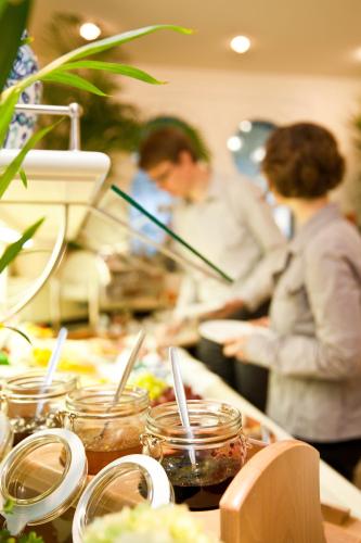 two people working in a kitchen preparing food at Boutiquehotel La Casa in Tübingen
