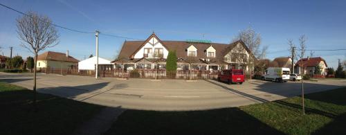a red van parked in front of a house at Koller Panzió in Bonyhád