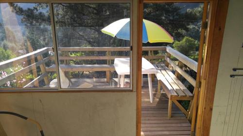 a balcony with a table and an umbrella at Refugios Olmue Santa Teresa in El Maqui