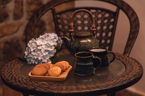 a table with a cup of coffee and a plate of food at The Xanadu Meghadootam in Kodaikānāl