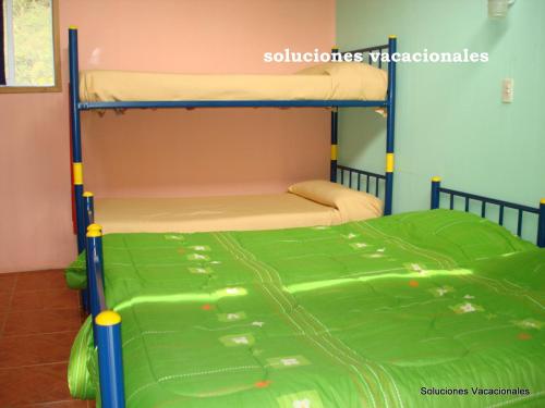a bunk bed in a room with a green mattress at Refugios Olmue Santa Teresa in El Maqui