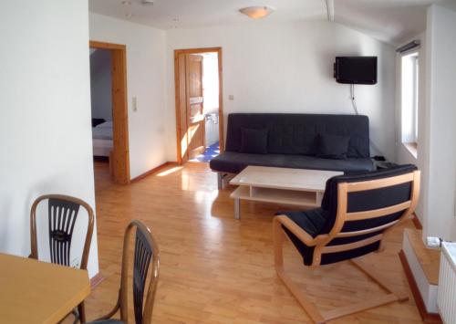 ein Wohnzimmer mit einem Sofa, einem Tisch und Stühlen in der Unterkunft Hotel Stadt Coblenz in Fachbach