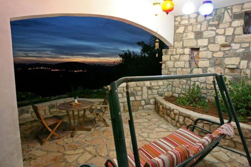 a patio with a table and a chair on a stone wall at Switzerland In Amirim in Amirim