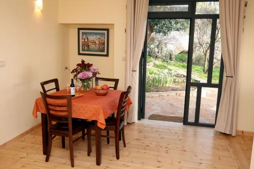 a dining room with a table and chairs and an open door at Switzerland In Amirim in Amirim
