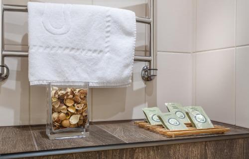 a bathroom counter with a vase of money and a towel at Jazz Hotel in Moscow