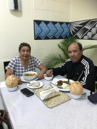 two people sitting at a table with plates of food at Moatoga Hotel in Apia