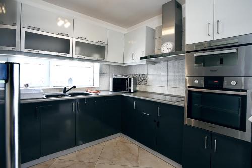 a kitchen with black cabinets and white appliances at Townhouse on Budapest border in Budaörs