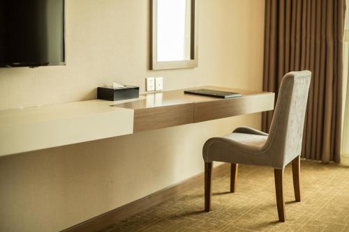 a chair sitting next to a desk in a hotel room at Muong Thanh Luxury Phu Tho in Việt Trì