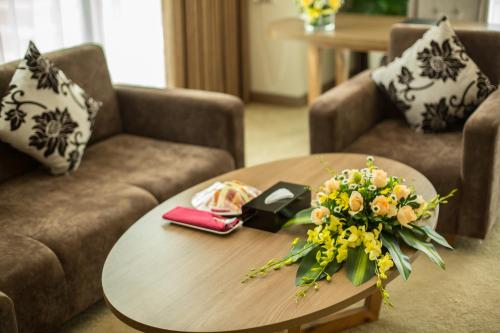 a coffee table with a bouquet of flowers on it at Muong Thanh Luxury Phu Tho in Việt Trì