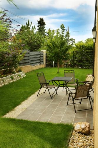 a patio with three chairs and a table in a yard at Townhouse on Budapest border in Budaörs