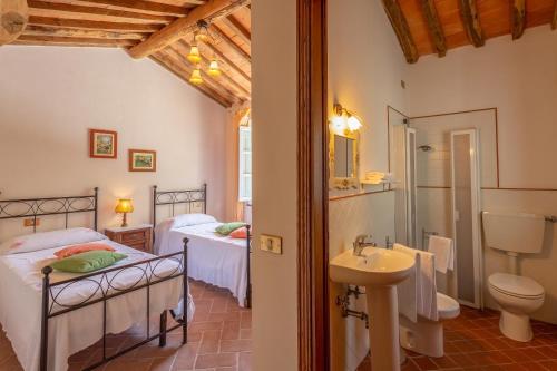 a bedroom with two beds and a sink and a toilet at Villa Mastiano in Mastiano