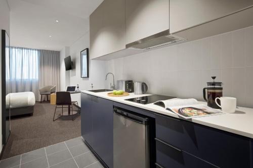 a kitchen with a sink and a counter top at Quest Penrith in Penrith