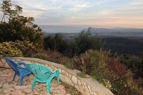 two blue chairs sitting on a wall with a view at Switzerland In Amirim in Amirim