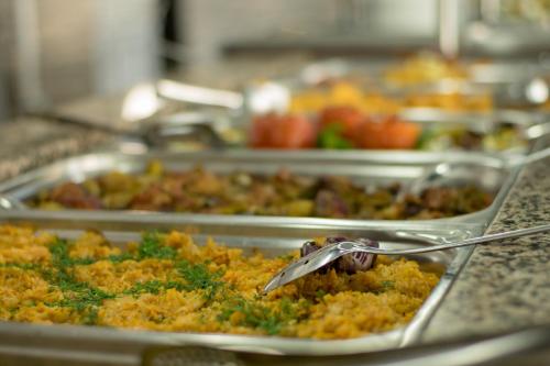 a buffet line with trays of food on a counter at Sineva Park Hotel - All Inclusive in Sveti Vlas
