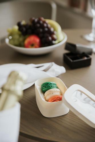 a table with a bowl of fruit and a plate of sushi at The LaLit London in London