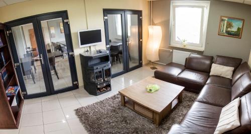 ein Wohnzimmer mit einem Sofa und einem Couchtisch in der Unterkunft Parkhotel Neubrandenburg in Neubrandenburg