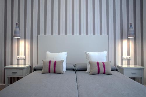 1 dormitorio con 1 cama grande y 2 mesitas de noche en Hotel Apartamentos MPD, en Mérida