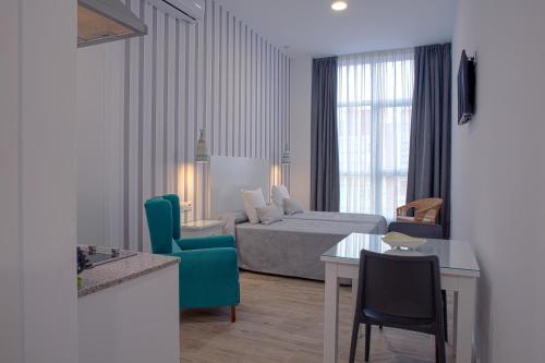 ein Hotelzimmer mit einem Bett und einem Tisch in der Unterkunft Hotel Apartamentos MPD in Merida