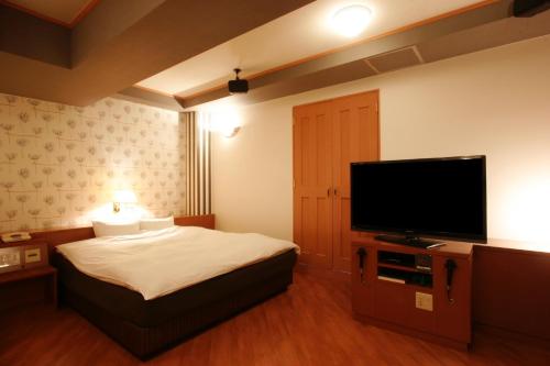 a bedroom with a bed and a flat screen tv at Hotel NOA (Adult Only) in Anjo