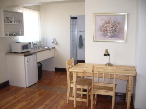 a kitchen and dining room with a table and chairs at Dee's BnB in Pretoria