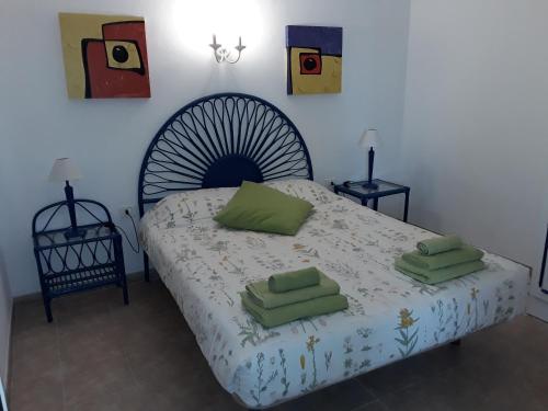 1 dormitorio con 1 cama con 2 almohadas verdes en modern bright apartment in Chayofita, en Costa del Silencio