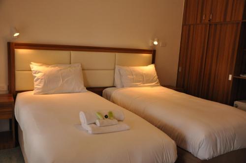 a hotel room with two beds with a stuffed animal on them at Miner's Retreat Motel in Ballarat