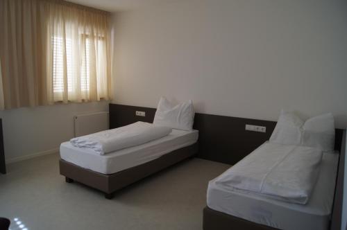 a bedroom with two beds and a window at Pension Lichtenburg in Nalles
