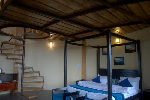 a bedroom with a bunk bed and a spiral staircase at The Misty Mountains in Chaukori