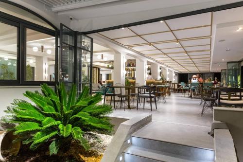 a restaurant with a plant in the middle of a room at Fanari Hotel in Fanárion