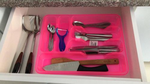 a pink tray with utensils in a box at Isramax apartment near the beach. in Bat Yam