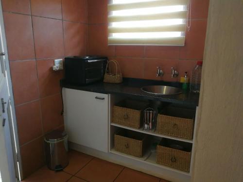 a small kitchen with a sink and a counter at The Fever Tree Guest House in Hluhluwe