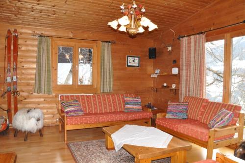 a living room with couches and a chandelier at Chalet Edelweiss in Weerberg