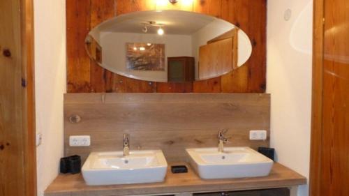 a bathroom with two sinks and a mirror at Ferienwohnung Haus Oberlarchhof in Bayrischzell