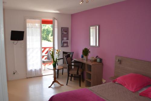 - une chambre avec des murs violets, une table et des chaises dans l'établissement Résidence Hôtelière Hélios, à Jonzac